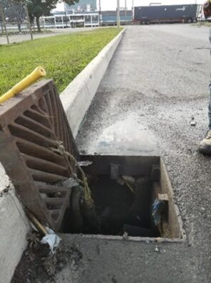Open catch basin with litter debris.